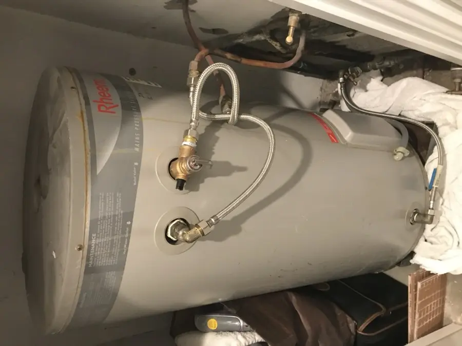 Top of electric hot water tank showing TPR valve and plumbing connections during service in North Narrabeen